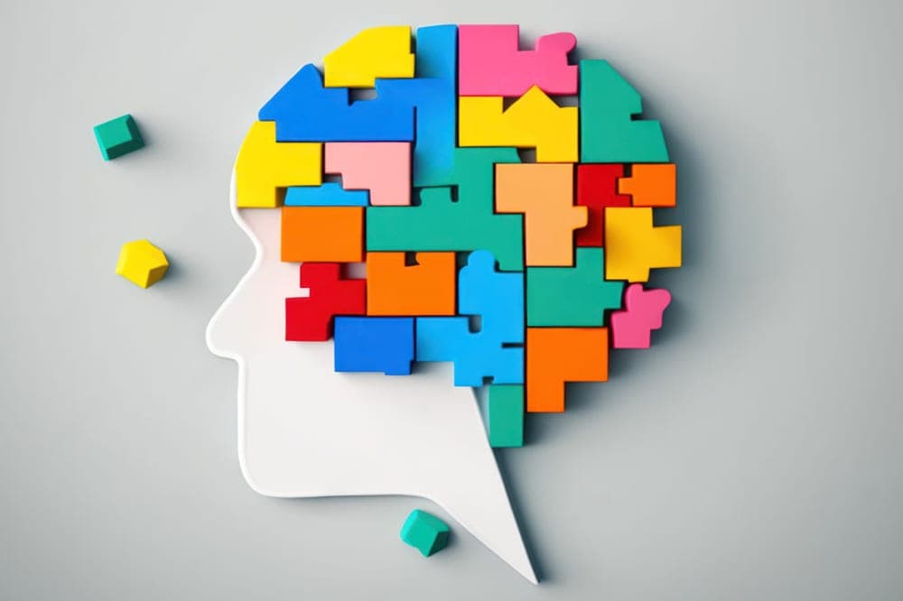 Neurodiversity is shown in an abstract fashion with children building blocks of various colours forming the shape of human brain to complete a puzzle