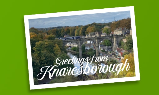 A Postcard with a rail bridge over a river, saying ‘Greetings from Knaresborough’.