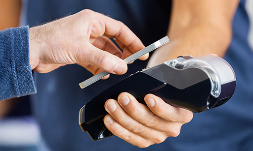 Someone holding their smartphone to a contactless payment machine.