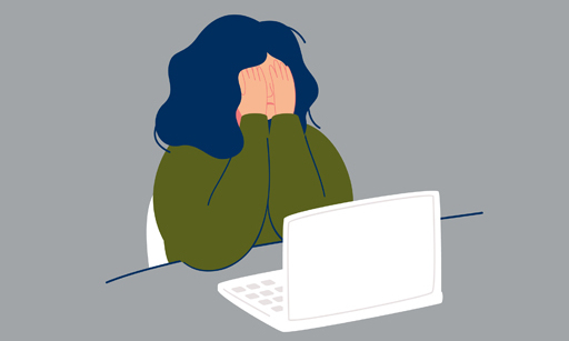 A woman at her laptop with her hands over her face.